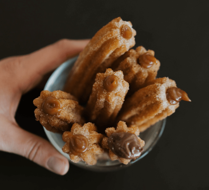 Churros filled with dulce de leche in a cup